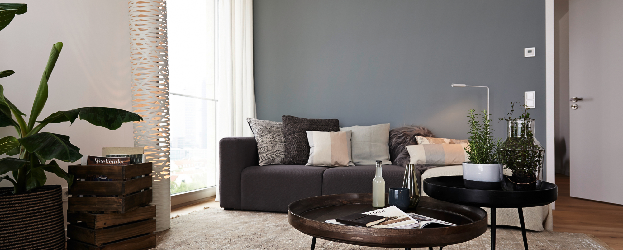 Wohnzimmereinrichtung mit Pflanzen, Sofa und Couchtischen
