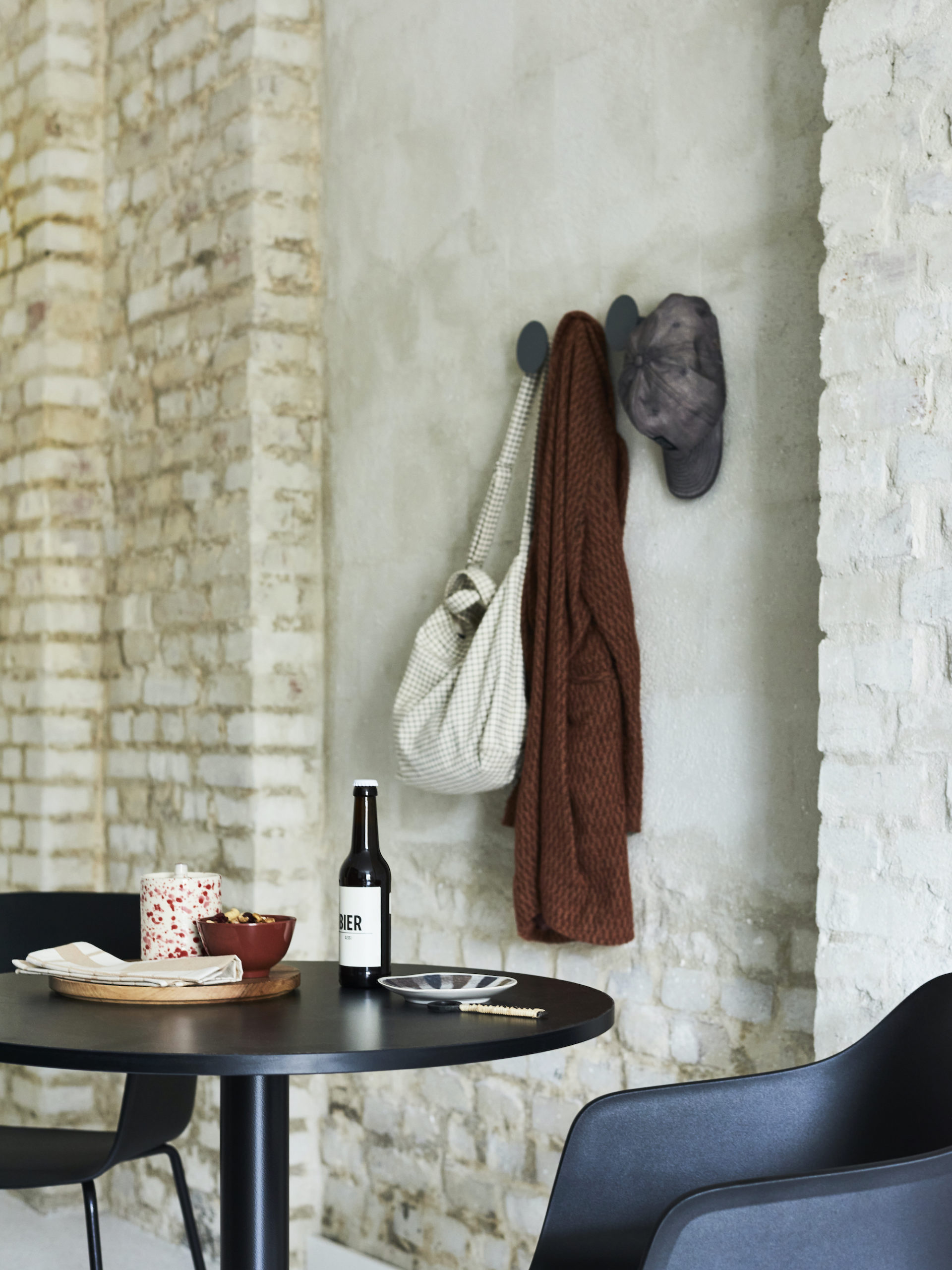 Garderobe an Steinwand mit vorgestellter Sitzgelegenheit