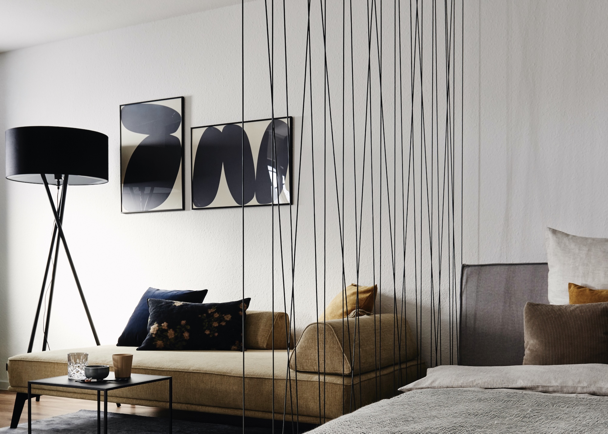 Der Praktische Raumtrenner zwischen Bett und Wohnbereich, schafft eine optische Zonierung.