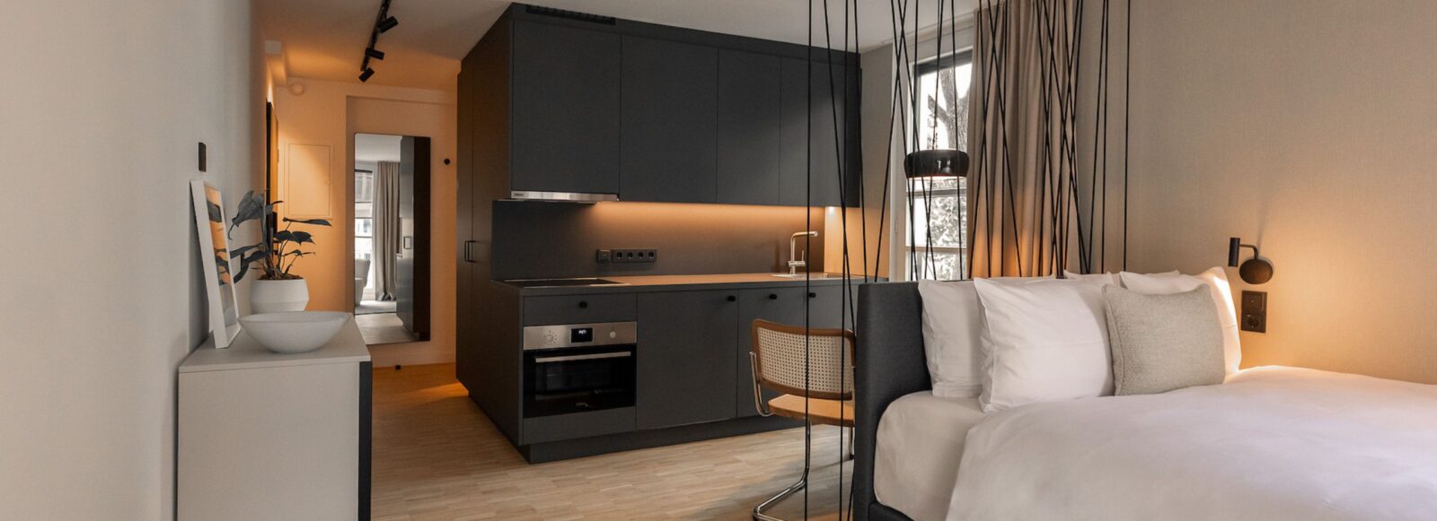 Blick in ein Serviced Apartmentzimmer von HApato mit Küche, Ess- und Schlafbereich