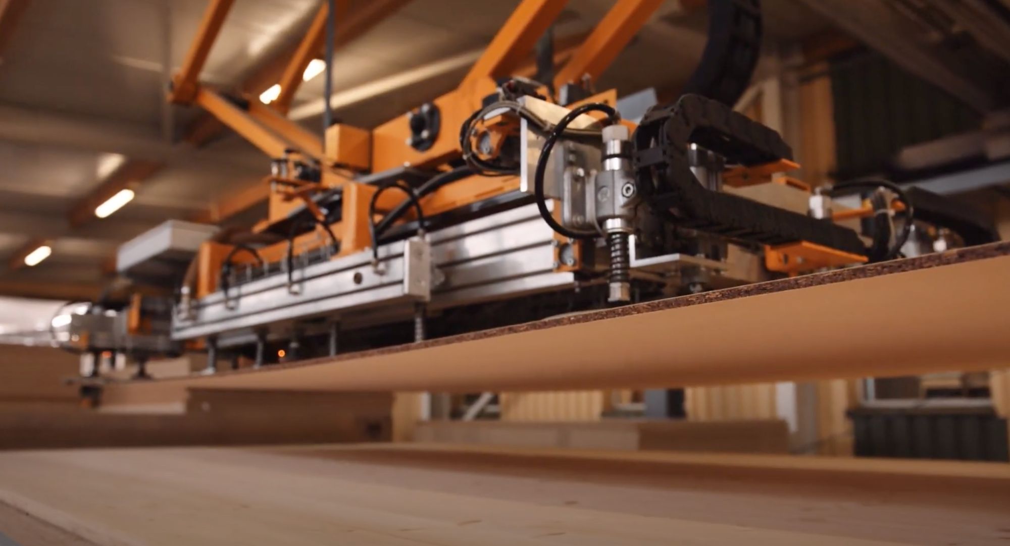 Automatisierte Fertigungsanlage bearbeitet eine Holzplatte in der Möbelproduktion