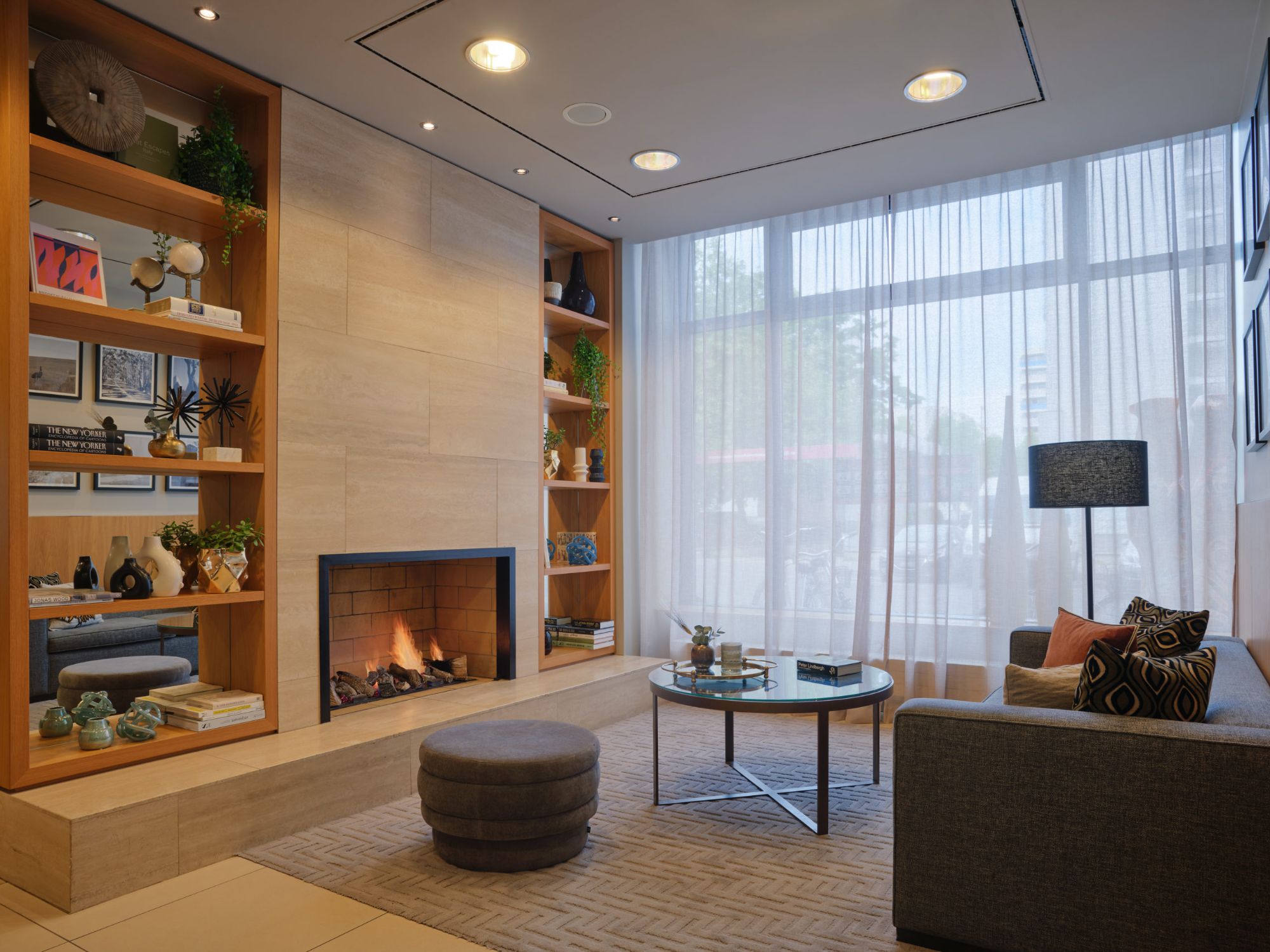 Lobby mit Kamin, Sitzgruppe und Regalen im Bob W in München Schwabing.